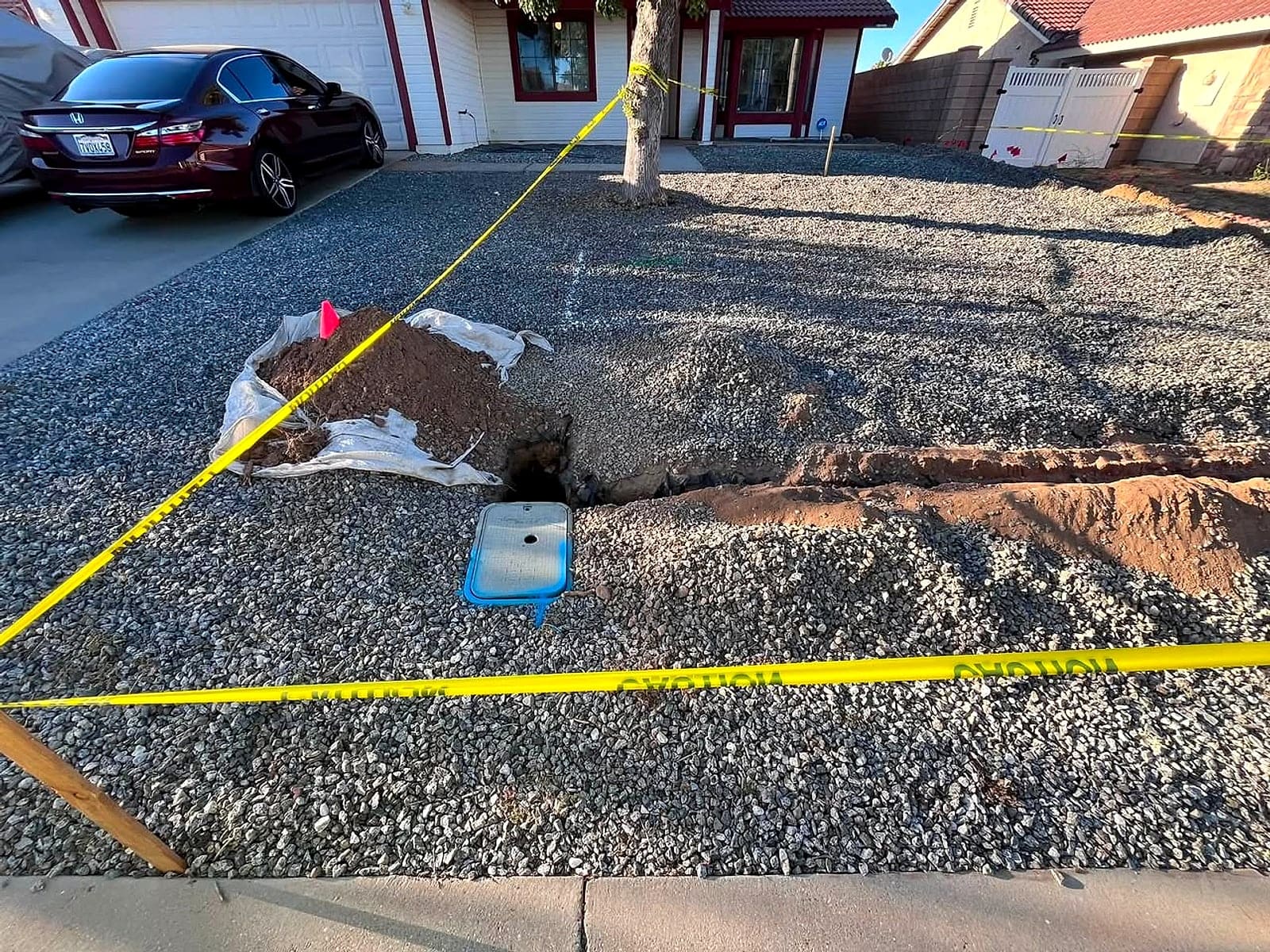 Front yard marked out with yellow string lines and a fresh trench on one of Pedro's jobs
